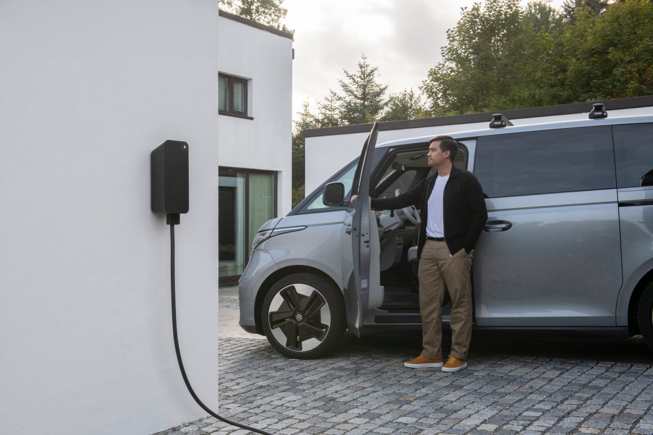 Amina smart charger installed at residential driveway with VW ID Buzz EV, showcasing compact Scandinavian design suitable for Bidirectional charging