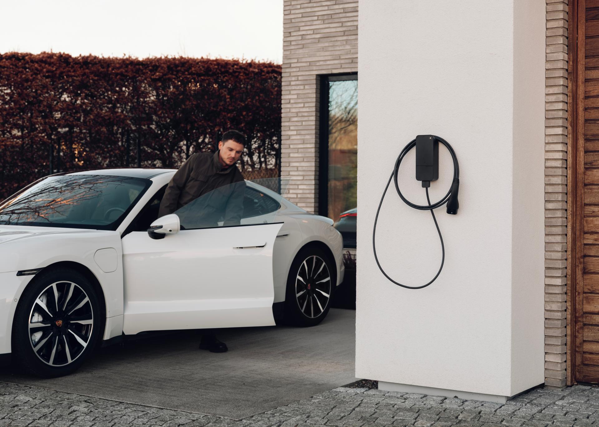 Amina smart charger installed at residential driveway with VW ID Buzz EV, showcasing compact Scandinavian design suitable for CPOs running chargers on ocpp